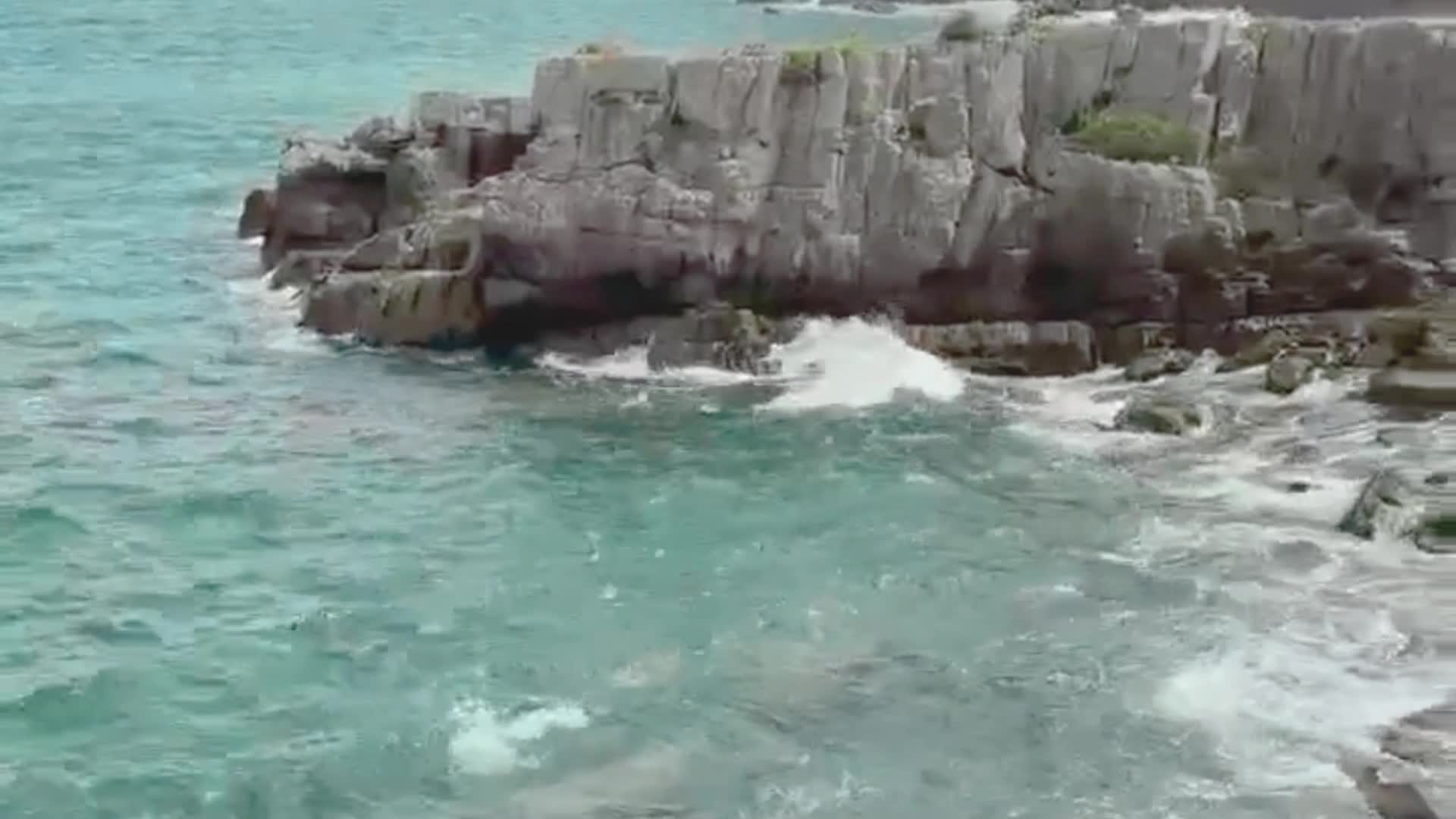 甑島の岩岸に寄せる青緑の波